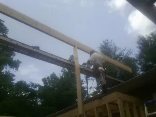 Carpenter setting a ridge beam over a new addition frame — Ice Dam Removal by Roofing Brothers in Eunice