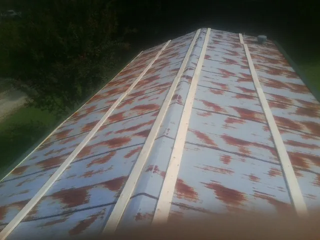 Rusted metal roof panels with new wood purlins before replacement — Storm Damage Roof Repair in Eunice by Roofing Brothers