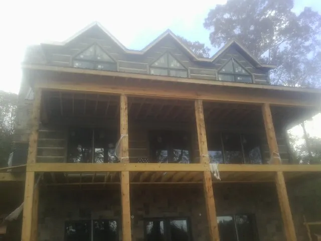 Dormers and porch framing on a large log home under construction — Roof Coating work by our crew in Eunice